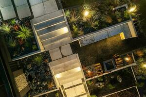 Night Time Aerial View of a Modern Backyard Garden with Architectural Concrete and a Fireplace. photo