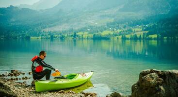 hombre relajante por lago después largo día de canotaje. foto