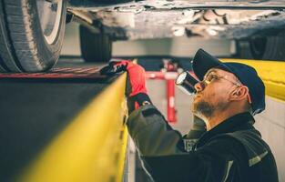 Car Mechanic Spotting Vehicle Suspension Problems photo