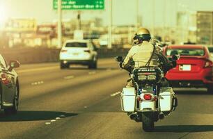 caucásico policía oficial en un motocicleta en un autopista foto