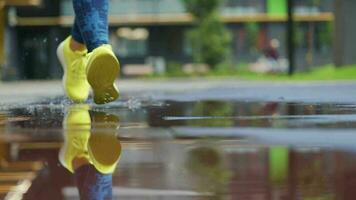 hembra Deportes mujer trotar al aire libre, pisar dentro charco. soltero corredor corriendo en lluvia, haciendo chapoteo. lento movimiento video