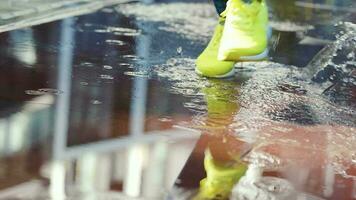 fêmea Esportes mulher corrida ao ar livre, pisar para dentro poça. solteiro corredor corrida dentro chuva, fazer splash. lento movimento video