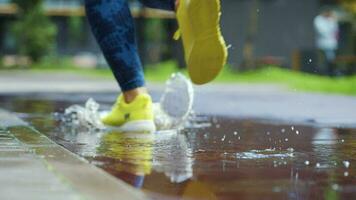 weiblich Sport Frau Joggen draußen, Schritt in Pfütze. Single Läufer Laufen im Regen, Herstellung Spritzen. schleppend Bewegung video