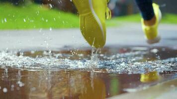 fêmea Esportes mulher corrida ao ar livre, pisar para dentro poça. solteiro corredor corrida dentro chuva, fazer splash. lento movimento video