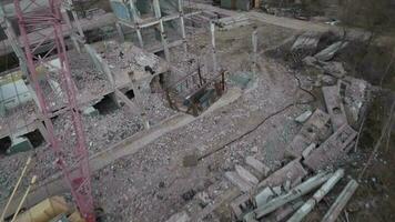 fpv zumbido moscas suavemente entre abandonado industrial edificios y alrededor un excavador video