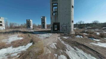 FPV drone flies quickly and maneuverably among the ruins of industrial buildings video