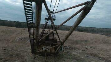 FPV drone flies maneuverable near rusty abandoned walking excavator video