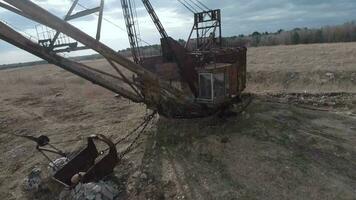 FPV drone flies maneuverable near rusty abandoned walking excavator video