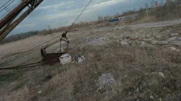 FPV drone flies maneuverable near rusty abandoned walking excavator video