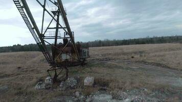 FPV drone flies maneuverable near rusty abandoned walking excavator video