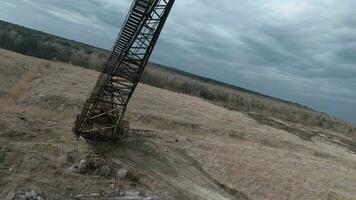 FPV drone flies maneuverable near rusty abandoned walking excavator video