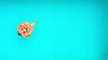 Aerial view of a woman in red bikini swimming on a donut in the pool video