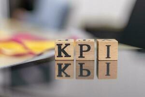 KPI letter on block cubes on wooden table, Key Performance Indicator business target concept photo