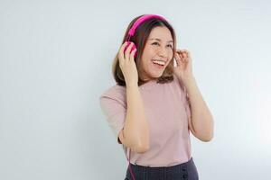 mujer asiática bailando y escuchando música en auriculares. foto