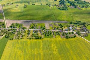 panoramic aerial view of eco village with wooden houses, gravel road, gardens and orchards photo