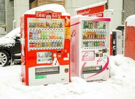 Supporo, Hokkaido, Japan 2018- Twin drink vending machine amid heap of snow and many snow falling. Even if it falls in the cold and heavy snow but the machine is still working good. photo