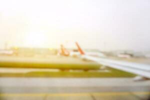 Blurred and outside view of airplane on the airport runway while the plane is prepared to takeoff with sky sun flare background. photo