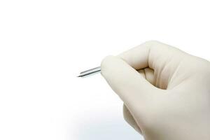 Closeup and croup hand of doctor in white medical glove and shadow holding blood lancet isolate on white background and make with paths. photo