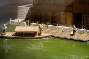 Miniature models and toy daily life of Japanese people and ancient transport wooden boat with home pontoon. photo