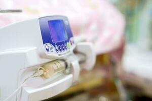 Syringe pump machine with monitor display pumping milk to sick newborn baby  at NUCU ward in the hospital. photo