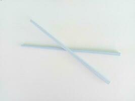 Blue plastic chopsticks on white background photo