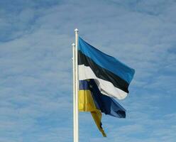 Estonia y UE banderas en contra nublado cielo. ondulación en el cielo foto