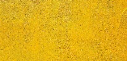 Yellow painted Rough or grunge concrete or cement wall for background - Retro wallpaper, Colorful, Painting and Texture of surface concept photo