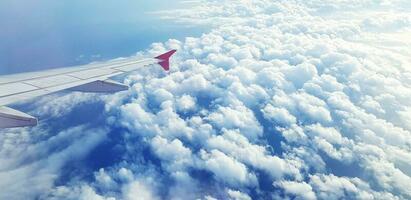 Aerial view of Aircraft or Airplane wing flying on sky and beautiful white clouds and copy space. Traveling, Soft of cloudy, Beauty of Nature at height est concept photo