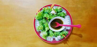 Shrimp salad bite recipes with spicy or sour sauce in white, red dish and and spoon on wooden table or background with left copy space at Vietnamese restaurant.Healthy eating life style and Asian food photo