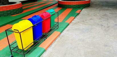 Colorful of four recycle bin or garbage for dumping waste on footpath with copy space. Cleaning city, Green world, Nature, Reduce material concept photo