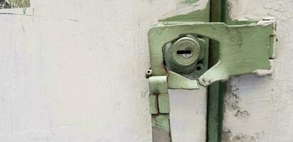 Green rustic keyhole damaged and broken of white painted cabinet with copy space. photo