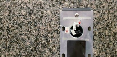 Wiring or electrical cable of Elevator push button switch panel install on black and gray marble wall with copy space. Electronic device and System installation concept. photo