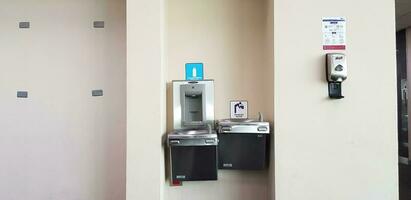 Bangkok, Thailand- May 28, 2023 Automatic drinking water and hand washers installed on wall in airport to provide services for passengers at Donmuang airport. Machine, Device Technology and Cleaning photo