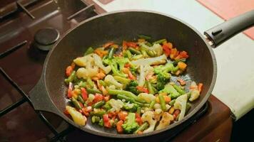 femelle mains ajoute une brouillé des œufs à frit des légumes tandis que cuisine omelette video