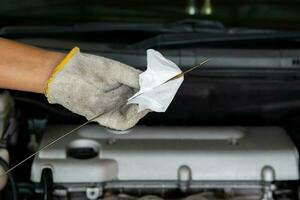 hand of a mechanic oil dipstick of the car photo