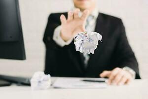 businessman emotions and fail concept crumpled paper on table with, unhappy no idea to thinking throwing papers in office photo