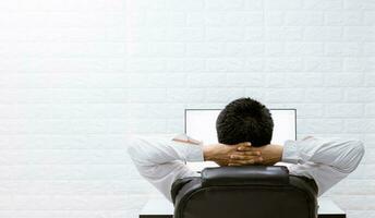 A man happy with watching computers, relaxing at work. photo