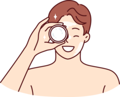 uomo dimostra vaso di crema comprato nel cosmetico memorizzare per idratare il suo viso o ottenere sbarazzarsi di rughe png