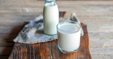 Bottles and milk glasses on a wooden table photo