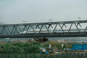 SHIZUOKA, JAPAN - APRIL 6, 2023 Tokaido Shinkansen crossing Fuji View Shinkansen rail bridge in the evening photo