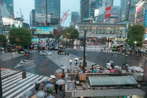 TOKYO, JAPAN - APRIL 8, 2023 View of Shibuya Crossing, one of the busiest crosswalks in the world in a raining day photo