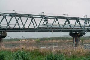 SHIZUOKA, JAPAN - APRIL 6, 2023 Tokaido Shinkansen crossing Fuji View Shinkansen rail bridge in the evening photo