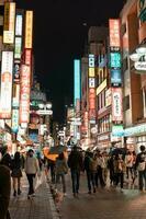 tokio, Japón - abril 8, 2023 personas caminando en shibuya compras zona en llovizna tarde foto