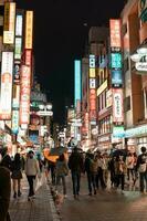 TOKYO, JAPAN - APRIL 8, 2023 People walking in Shibuya shopping area in drizzle evinging photo