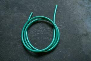 photo of a green water hose on a roll