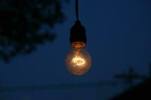 photo of yellow light bulb glowing at night