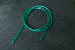 photo of a green water hose on a roll