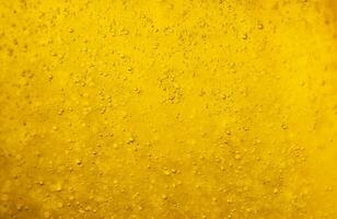 Air bubbles or bubbles of various sizes floating in a golden yellow liquid or gold background for use as wallpaper. photo