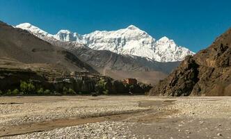 el himalaya pueblo de kagbeni en Superior mustango en el Annapurna circuito trekking sendero en Nepal con el nieve cubierto nilgiri norte imponente encima él. foto