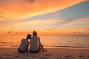 Pareja en amor acecho puesta de sol juntos en playa viaje verano vacaciones. personas silueta desde detrás sentado disfrutando ver puesta de sol mar en tropical destino vacaciones. romántico Pareja en el playa foto